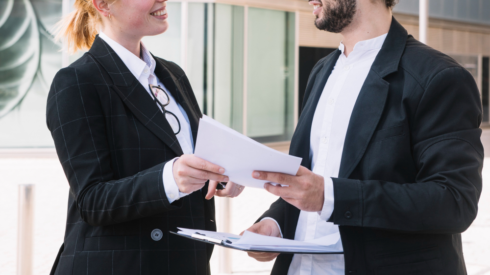 Businessman and businesswoman holding documents in hands