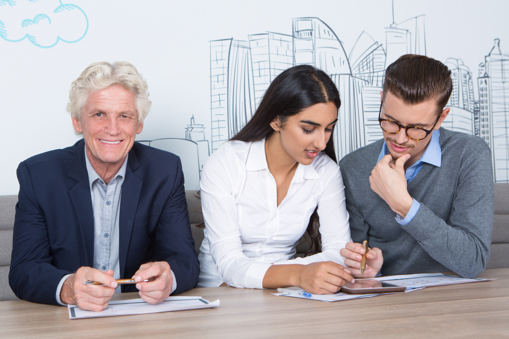 Three content colleagues working at cafe table
