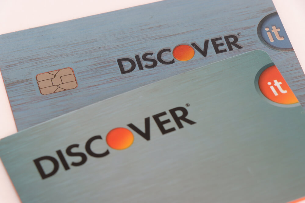 Two stacked Discover cards Two blue Discover cards stacked laying on a white surface