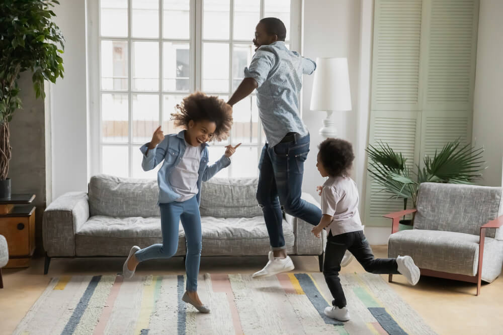 A family is joyfully jumping in the living room.