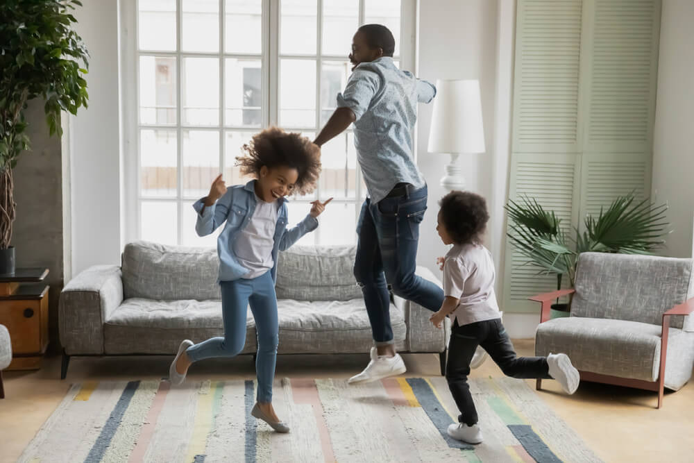 Dad dancing in the living room with his daughter and son 