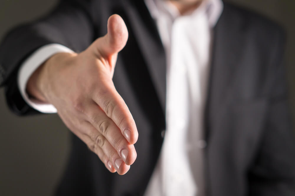 A closeup of a businessman offering his hand for a hand shake
