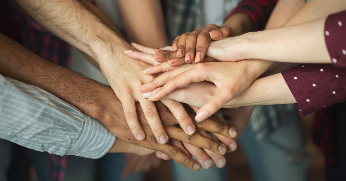 Multiple people with their hands in a pile