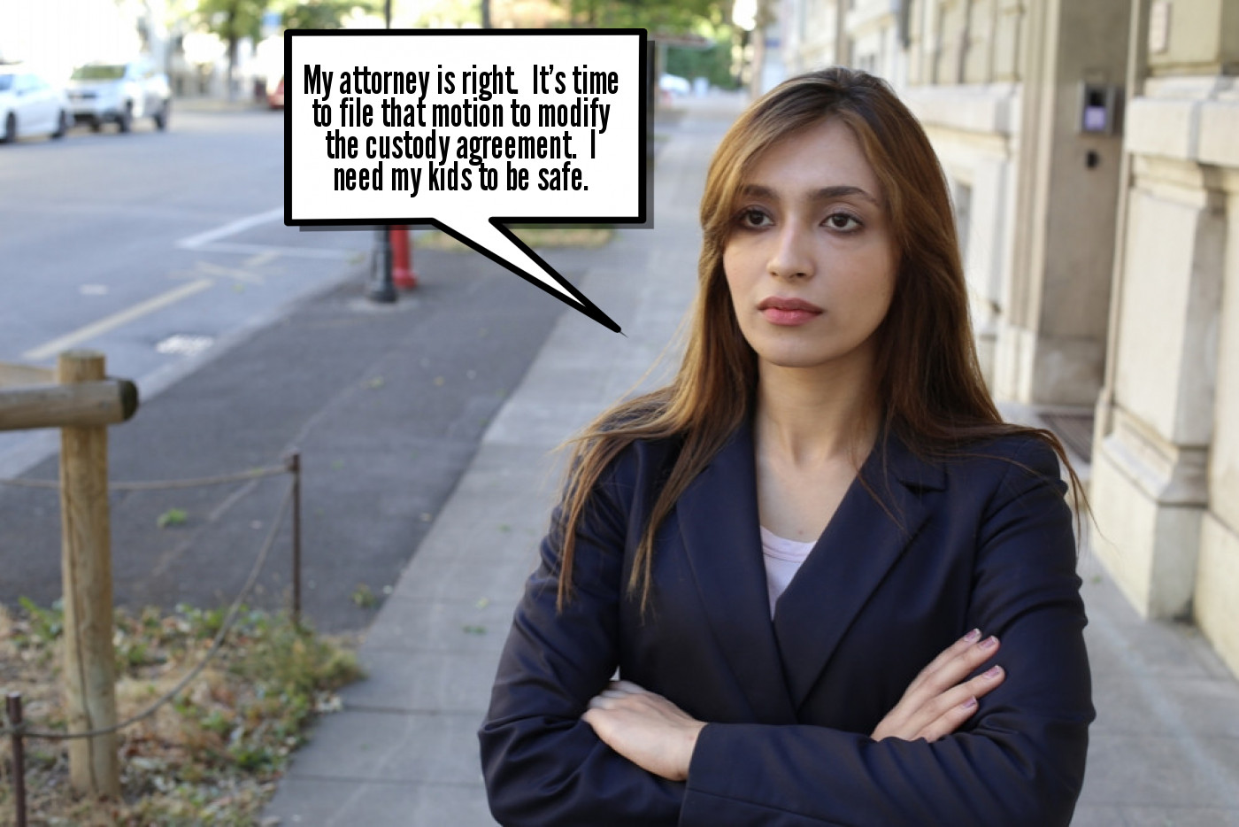 A woman in a suit standing on a sidewalk with a speech bubble.