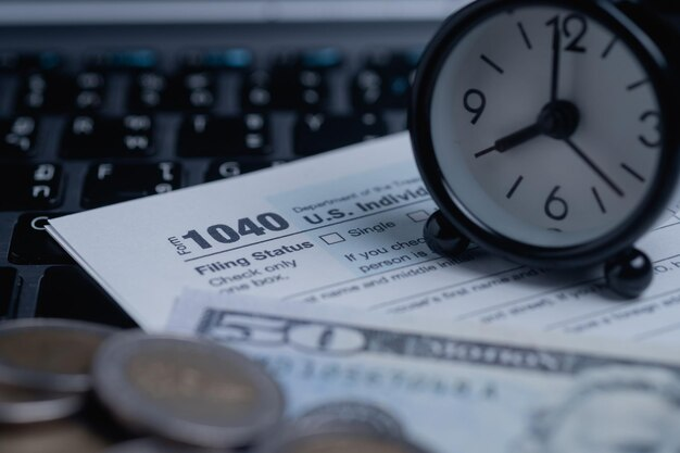 A clock sits on top of a tax form, reminding individuals about looming deadlines and the potential consequences if debt collectors decide to sue them.