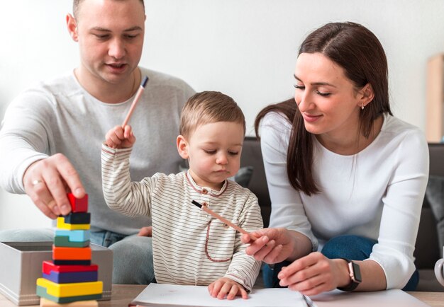 A family with a child playing with blocks at home.