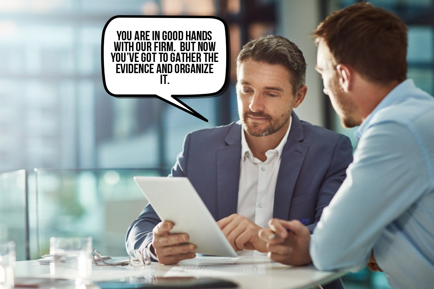 Two men are talking at a table with a speech bubble.