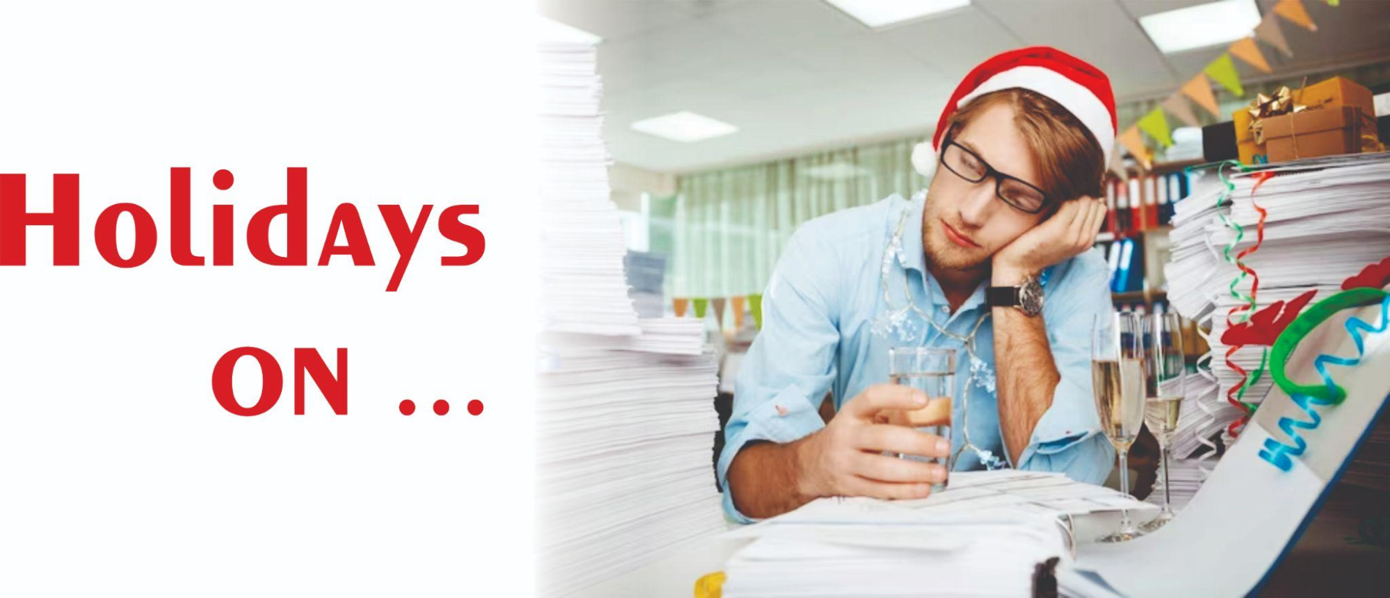 A man in a santa hat is sitting in front of a pile of papers with the words holidays on.