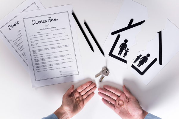 A couple of people holding papers with a house and a key.