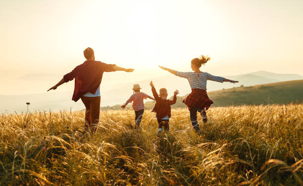 Happy family: mother, father, children son and daughter on nature on sunset, showing up for kids