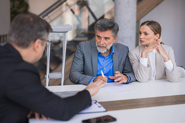 Mature couple discussing legal documents with lawyer in office