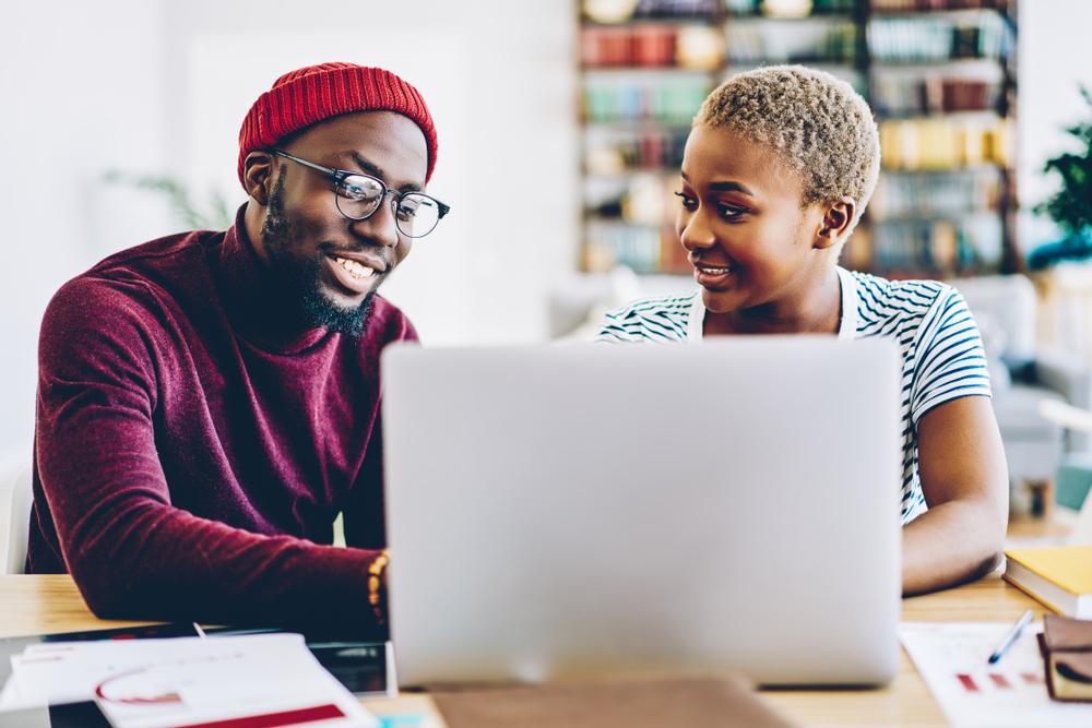 Man and women sitting in front of a computer making a plan with each other