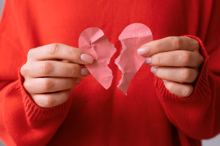 a girl in red sweater holding a broken paper heart of pink color, How to File for Divorce in Collin County