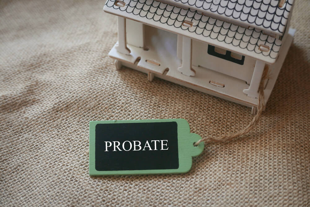 A small wooden house with a probate written on a tag attached to the house