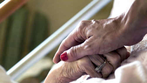 A careworker offers comfort and solace to a hospice patient in article, lady bird deed medicaid