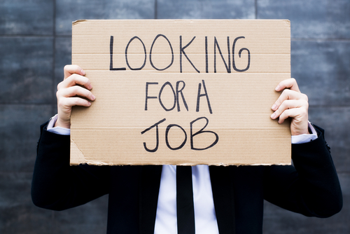 Young business woman holding sign Looking for a job in article, who suffers most in divorce