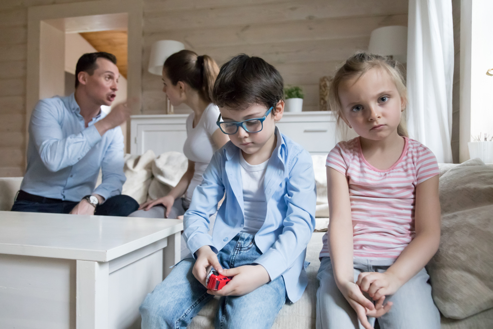 Sad children listen parents have angry fight at home. Stressed kids looking at camera, mom and dad shout. Violence, divorce, family problems, bad relationship negative impact on mental health concept