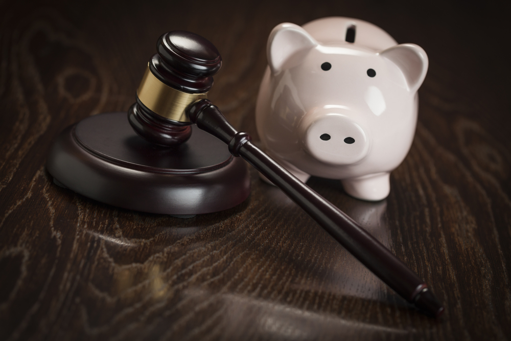 Gavel and Piggy Bank on Wooden Table.
