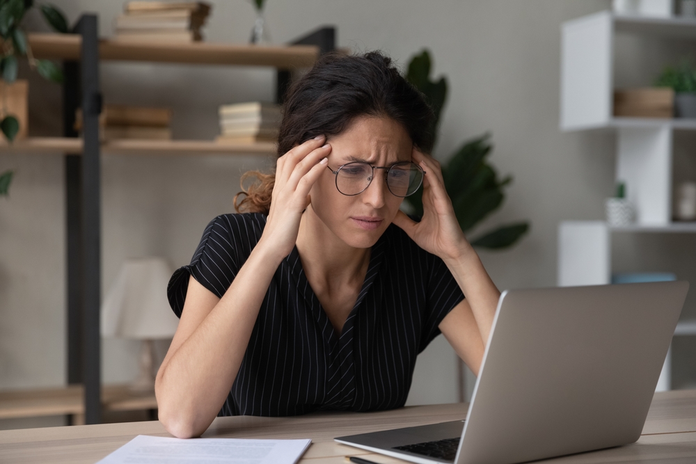Stressed millennial latina hispanic woman in glasses looking at computer screen, stack with difficult task, searching problem solution, having problems with online project, bankruptcy concept.