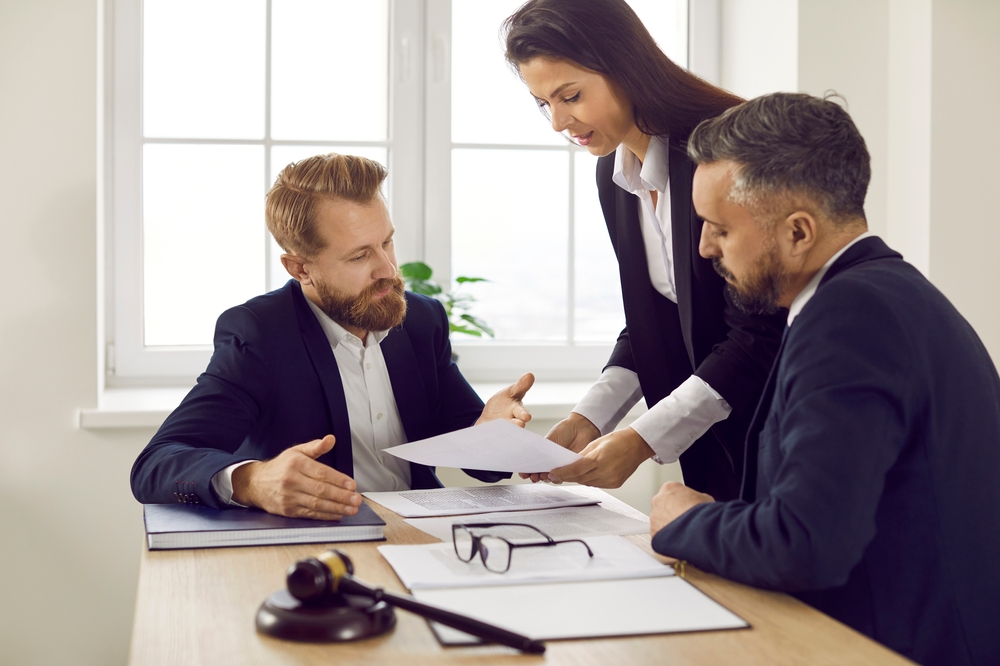Group of experienced attorneys and lawyers giving consultation to client, helping with difficult lawsuit, explaining legal procedures and discussing agreement terms. 