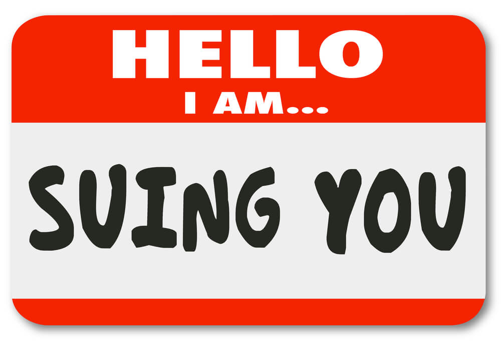 A red sticker that says hello I am and then written out says suing you