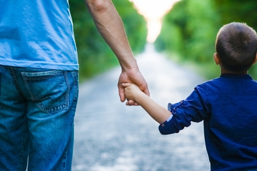 Hands of a child and a parent in nature on the road journey background, can permanent custody be overturned