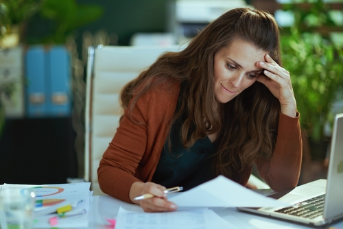elegant 40 years old small business owner woman working with documents in the modern green office.