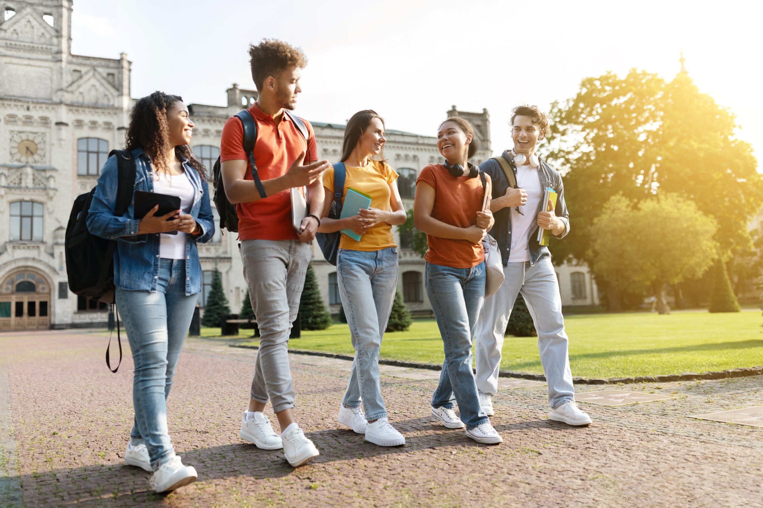 Group of college students walking and talking on campus.