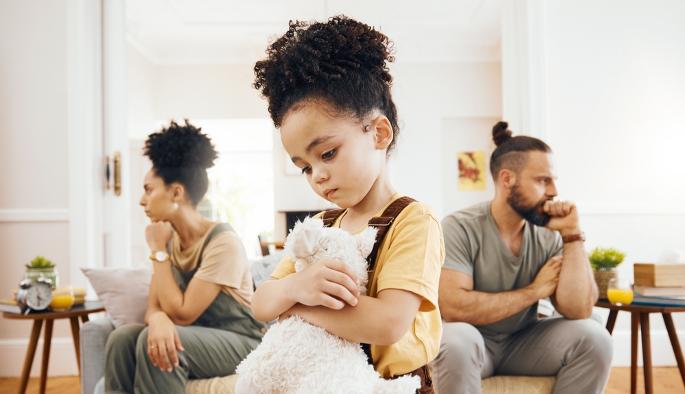 Divorce, custody and sad boy child with teddy bear in living room for stress, support and comfort at home. Family, crisis and kid with anxiety for toxic parents, argue or dispute, depression or fear