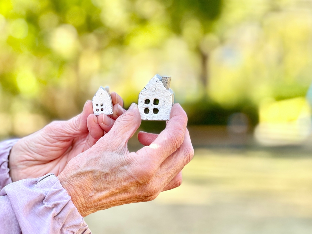 Elderly woman holding two household items