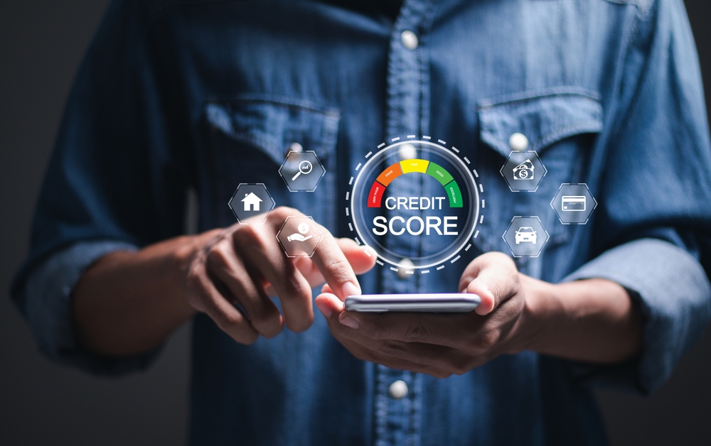 A person using a smartphone with a virtual credit score dashboard and financial icons displayed.