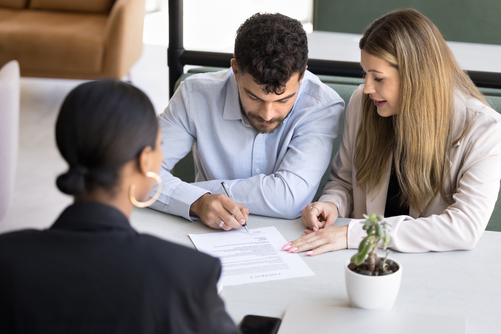 Focused married couple signing document, after consulting lawyer, realtor, law advisor, mentioning importance of how to choose a family law attorney