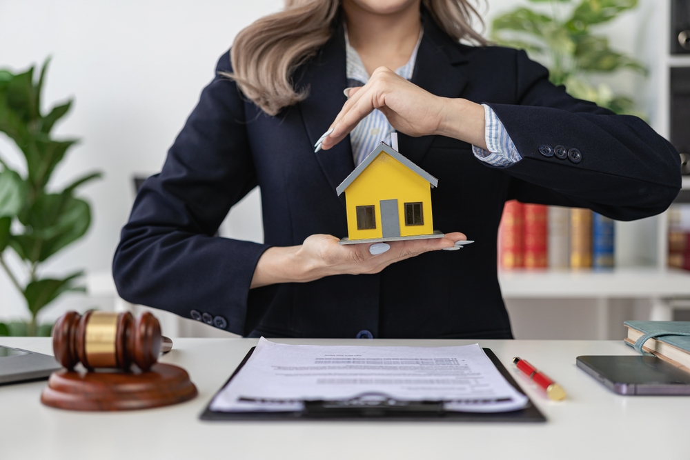 House model, judge hammer on wooden table, foreclosure, bankruptcy concept. A person is unable to pay outstanding debts or obligations, has stopped making mortgage payments, house auction concept.