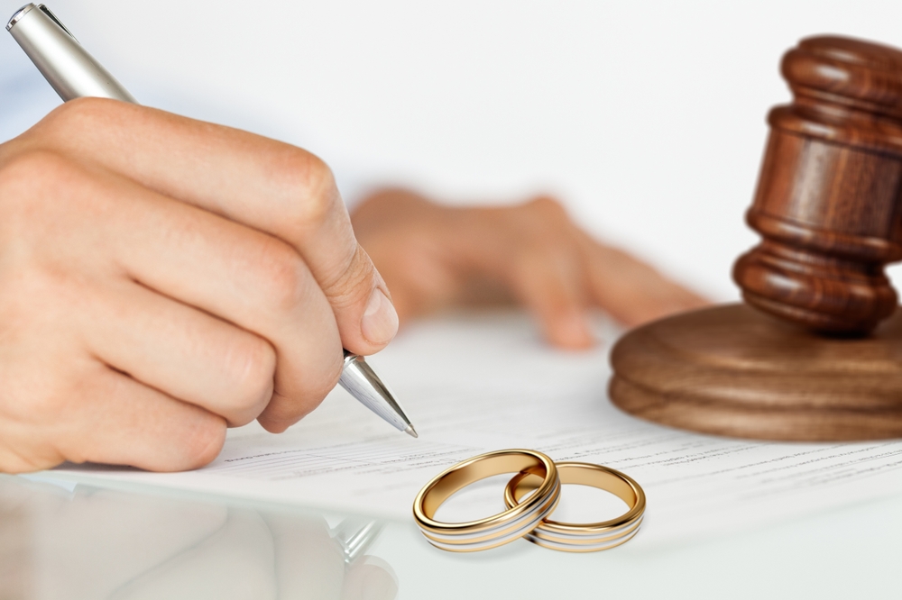 Wedding rings on table with judge gavel. Marriage and divorce