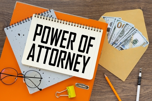 power of attorney top view of text on notepad and money bills in envelope