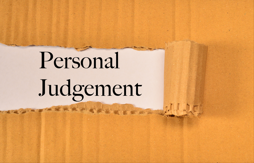 A piece of cardboard is torn open to reveal the words "Personal Judgement" printed on white paper underneath