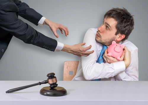 Distraint, bankruptcy and execution concept. Confiscation of savings in piggy money bank. what happens if a debt collector takes you to court