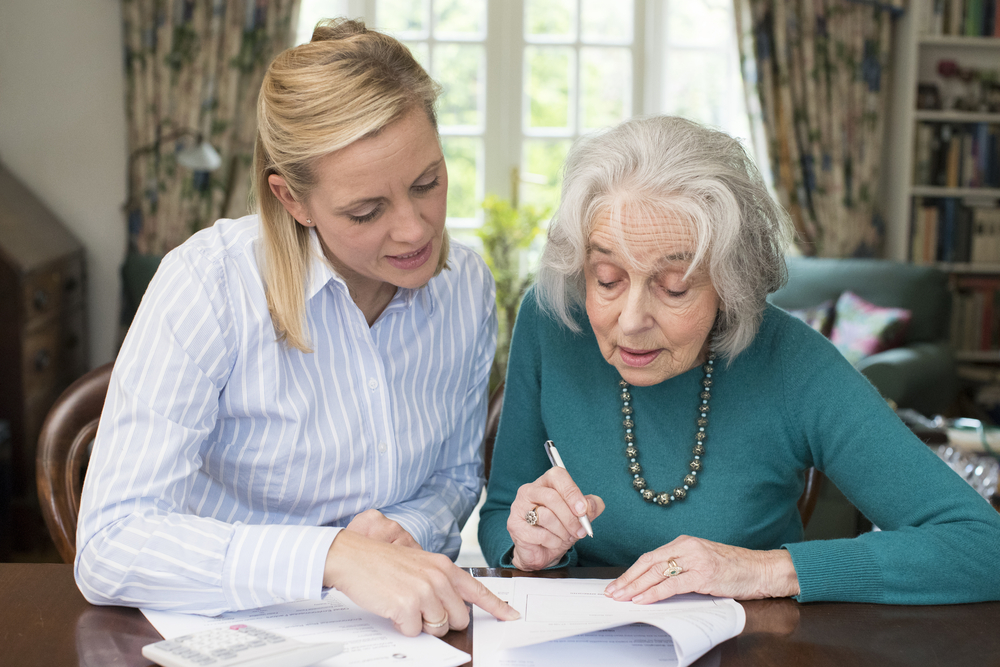 Woman Helping Senior Neighbor With Paperwork in the article Can a POA Change a Will