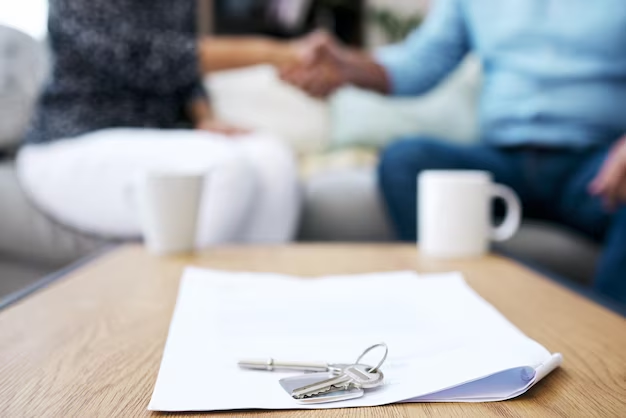 Two person shaking hands at a table.