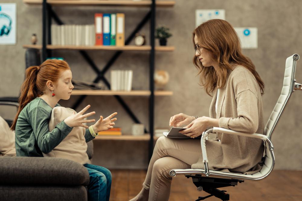 A woman is talking to a girl in an office chair, discussing divorce proceedings.