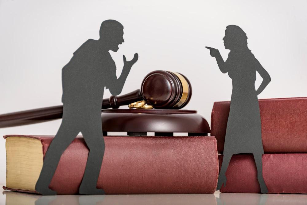 A couple of paper cutouts on a gavel representing legal documents.