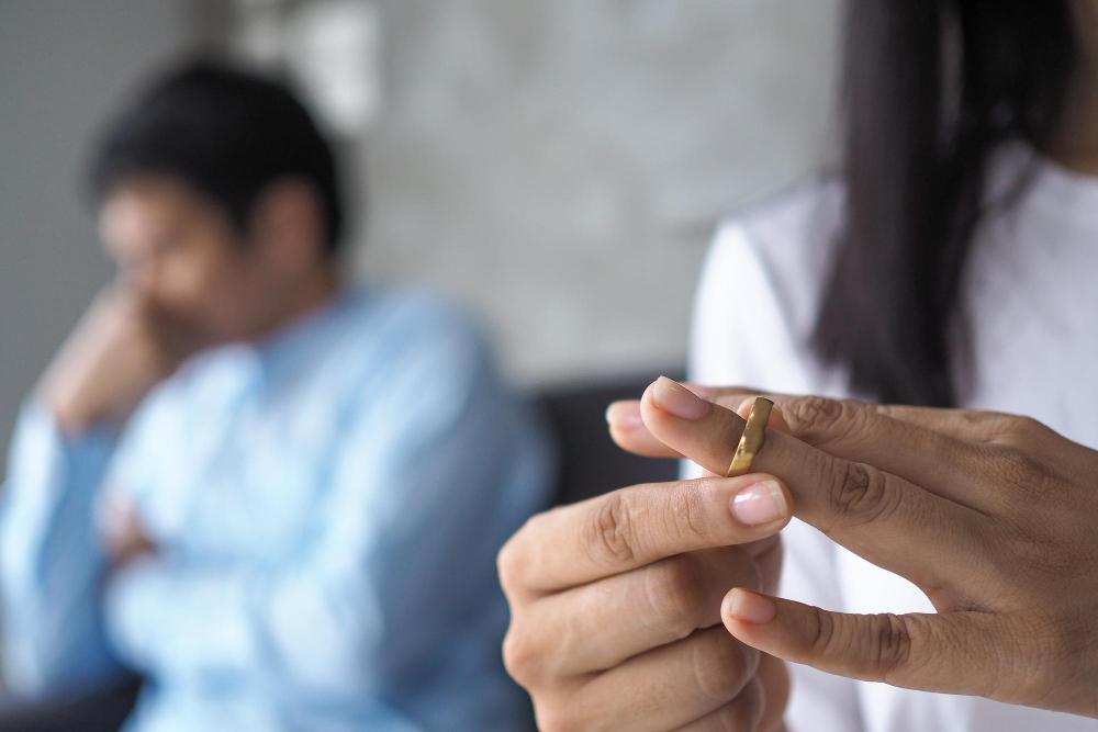 A close-up of a woman slipping a wedding ring on her finger.