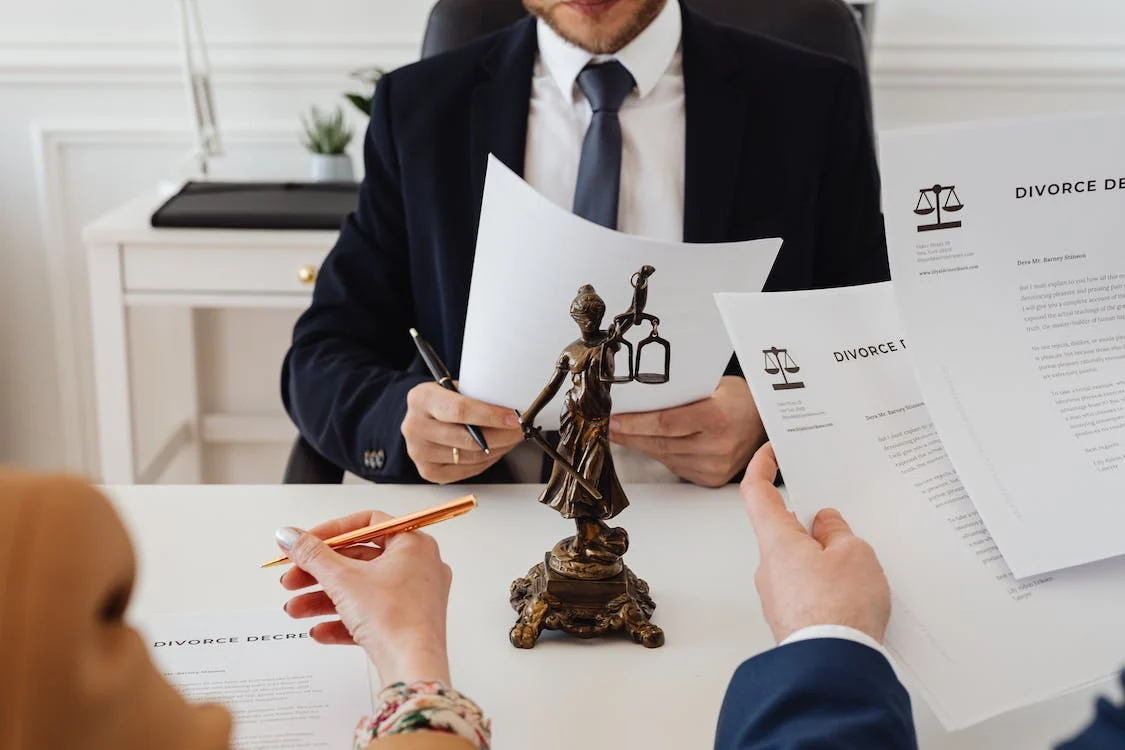 A lawyer reviews divorce papers with a client in an office.