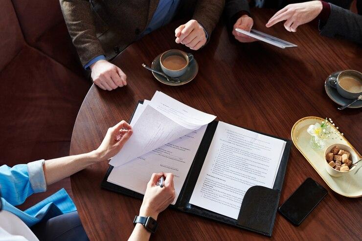 Professionals discussing documents over a coffee table.