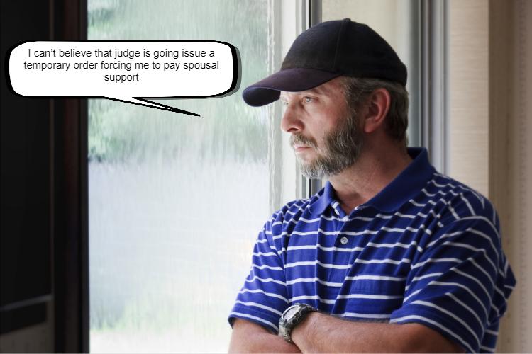 A middle-aged man with a beard, wearing a cap and striped polo shirt, looking out a window with a thoughtful expression on his face, 
