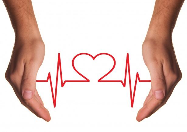 Two hands are open, with palms facing each other, surrounding a red heart symbol integrated into a heartbeat line on a white background, symbolizing the importance of health info sharing.